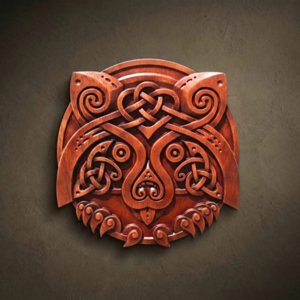 A high-end circular wood relief carving of a raccoon's head, masterfully stylized with Celtic knotwork. The design features symmetrical spirals for the eyes and ears, with intricate interlocking braids forming the mask and facial features. Hand-finished in a deep mahogany stain that highlights the artisan's precision and the natural wood grain.