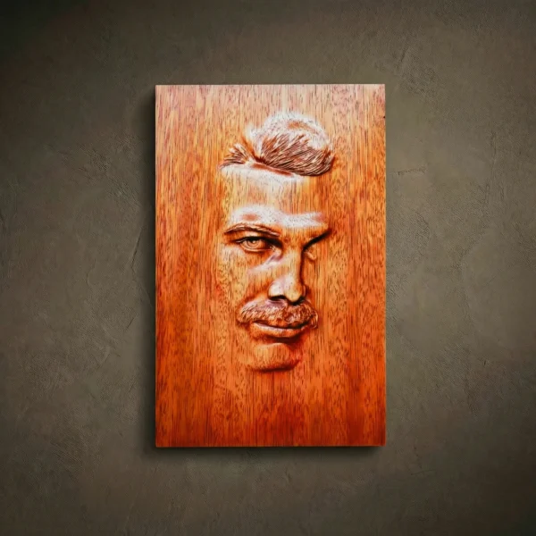 Custom hand-carved Iroko wood portrait relief. This personalized wood carving features a realistic male face with high-detail hair and mustache textures, finished with natural oil to highlight the grain. An example of a bespoke 3D wooden portrait from a photo, perfect for unique custom-made gifts and commemorative wall art.