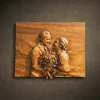 Custom hand-carved Iroko wood relief portrait of a couple laughing together. This high-detail personalized carving shows a man in a suit and a woman holding a large, intricate flower bouquet, finished with natural oil to bring out the warm wood tones. A premium example of a bespoke wedding gift or custom anniversary portrait carved from a photo.